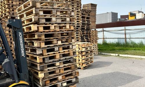 Погрузчик перевозит деревянные поддоны